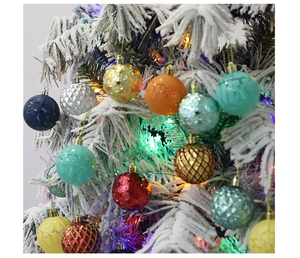 Macro shot of assorted colorful Christmas baubles with sequins and relief patterns on tree