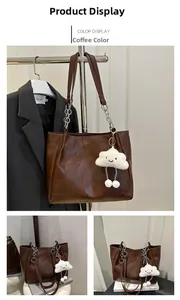 Détail du sac cabas en similicuir marron avec bandoulière en chaîne et bijou de sac