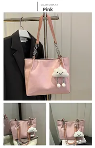 Détail du sac cabas rose à texture géométrique avec chaîne argentée et bijou en peluche