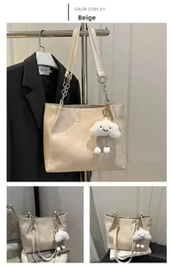 Vue détaillée du sac cabas beige avec chaîne argentée et breloque nuage blanc