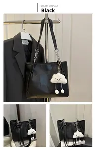 Détail du sac cabas noir avec patchwork géométrique et pendentif nuage blanc