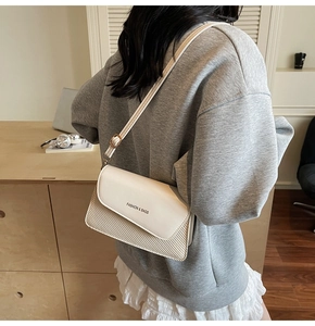 Detail of cream rectangular crossbody bag showing leather and woven texture mix