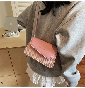 Pink faux leather and straw woven crossbody bag with fashion text detail shown with model