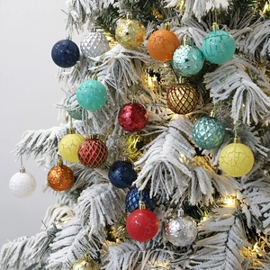 Colorful Christmas ball ornaments with star and lattice textures on a snowy tree