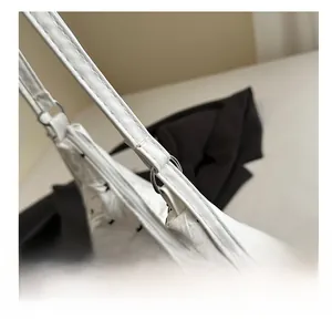 Close-up of white tote bag strap metal ring link and reinforced stitching detail