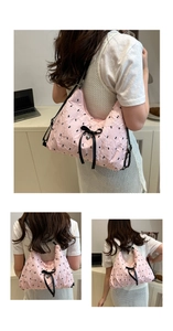 Pink bubble texture shoulder bag with black bows and heart pendant detail view
