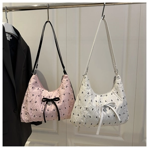 Detail of fabric tote bag with butterfly patterns and heart-shaped metal pendant charm