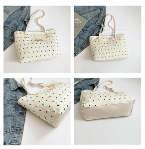 Detail of off-white tote bag with black bow prints and golden metal bow ornament