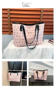 Detail of pink quilted tote bag with black bow print and golden metal hardware