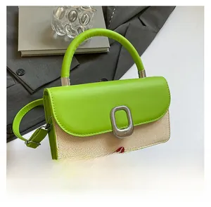 Detail of green faux leather and beige woven fabric crossbody bag with silver oval lock