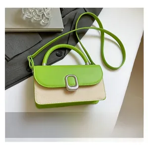 Close-up of a two-tone woven crossbody bag with green leather trim and metal buckle