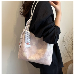 Détail du sac à main rose clair à broderie florale avec poignée en foulard décoratif