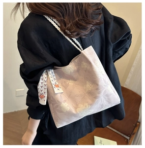 Détail du sac seau floral avec poignées en corde tressée blanche et détail de foulard