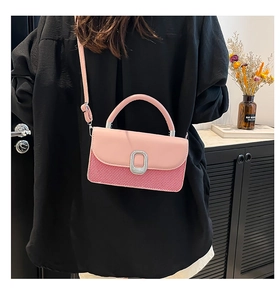 Detail of pink and red crossbody bag with silver oval buckle and adjustable strap