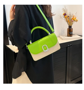 Detail of trendy color-block crossbody bag with green flap and silver metal buckle