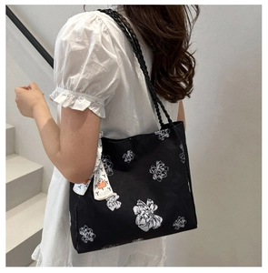 Détail d'un cabas floral en toile avec anse corde tressée et foulard en soie décoratif