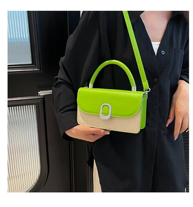 Close-up of green leather and beige woven fabric vintage handbag with silver metal buckle