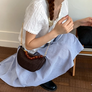 Sac bandoulière demi-lune tressé marron avec chaîne dorée et perle en résine ambre