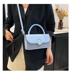 Detail of light blue crossbody bag featuring mixed faux leather and twill fabric texture