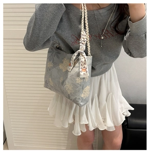 Détail du cabas gris à fleurs avec poignées en corde tissée et foulard en soie décoratif