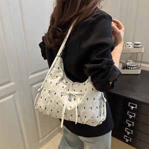 White ruffled shoulder bag with bunny print, white bow, and silver heart pendant detail