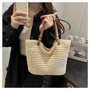 Dettaglio borsa shopper all'uncinetto crema con manici in pelle marrone e rivetti