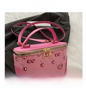 Detailed close-up of a pink box-shaped bucket bag featuring a vibrant cherry print pattern