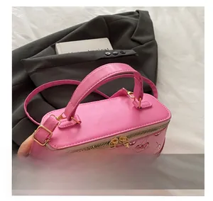 Pink bucket bag featuring red cherry prints, dual metal zippers and gold hardware detail