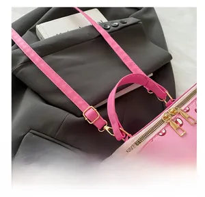 Detail view of pink cherry print bag showing the adjustable golden buckle and leather strap