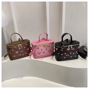 Detailed view of cherry print bucket bags with dual zippers and gold-tone metal hardware