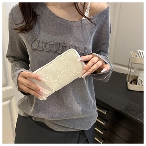 Detailed view of white faux leather wallet with heart-shaped texture and zipper