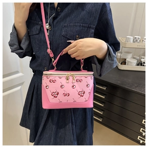 Detail of pink cherry print box handbag with double metal zipper and leather handle