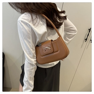 Close-up of brown crescent bag with stylish silver bow buckle and smooth leather texture