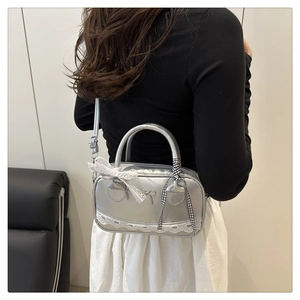 Detail of silver lace Boston bag with bow and plaid ribbon shown on a shoulder