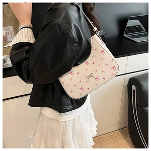 Detail of white floral shoulder bag with pink bow prints and silver metallic buckle decoration