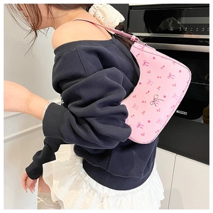 Close-up of pink floral hobo bag with bow prints and silver metal buckle detailing