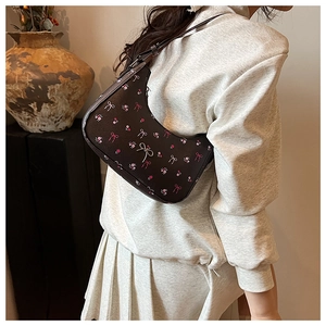Detailed view of floral hobo bag with pink bow prints and silver metallic buckle