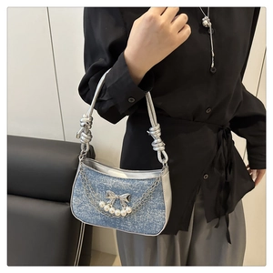 Detail der hellblauen Jeans-Handtasche mit silberner Schleife, Perlen und Knotengurt