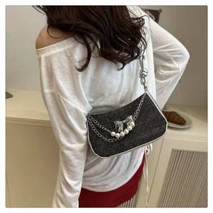 Detail of black glitter shoulder bag with silver leather trim and bow pearl chain