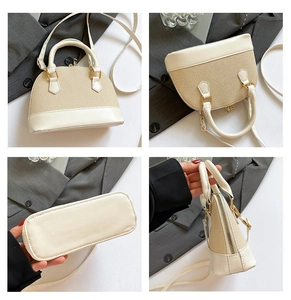 Detail view of beige leather and straw shell bag showing stitching and metal hardware