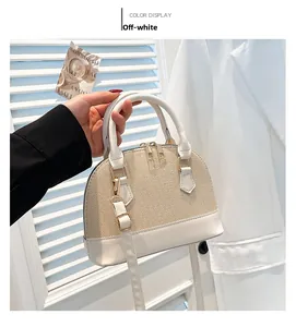 Detail of a beige shell-shaped handbag with straw texture and white leather accents