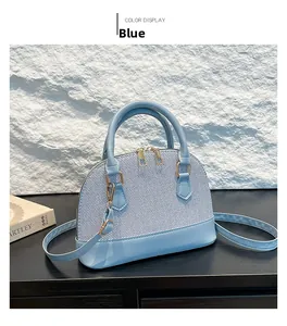 Detail shot of light blue shell-shaped bag with textured fabric and gold zipper