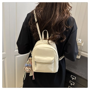 Detailansicht beige Mini-Rucksack aus Kunstleder mit Bärenanhänger auf dem Rücken