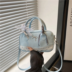 Light blue Boston bag with white lace trim and ribbon bows, ballet style handbag