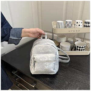 Details des silbernen Metallic-PU-Rucksacks mit Fronttasche und praktischem Tragegriff