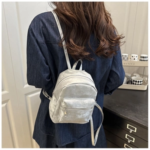 Silberner Mini-Rucksack mit Autumn-Prägung in einer häuslichen Lifestyle-Umgebung