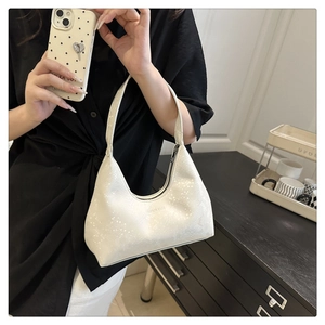 Nahaufnahme einer weißen Hobo-Bag mit schimmernder Perlglanz-Textur und Reißverschluss