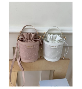 Detail of trendy bucket bags with textured fabric and elegant drawstring inner pouch