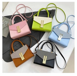 Flat lay of small crossbody bags in five colors with gold buckles and textured flaps