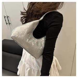 Silver metallic hobo bag with snakeskin texture shown on model in modern home setting